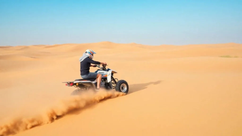 Tourist enjoying quad biking in Abu Dhabi desert safari adventure on sand dunes