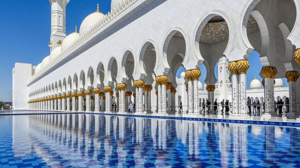 Sheikh Zayed Grand Mosque in Abu Dhabi with white marble arches and blue water reflection
