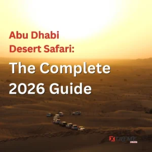 A convoy of white 4x4 SUVs navigating golden sand dunes at sunset during a desert safari in Abu Dhabi, with rolling dunes and a warm amber horizon stretching into the distance.