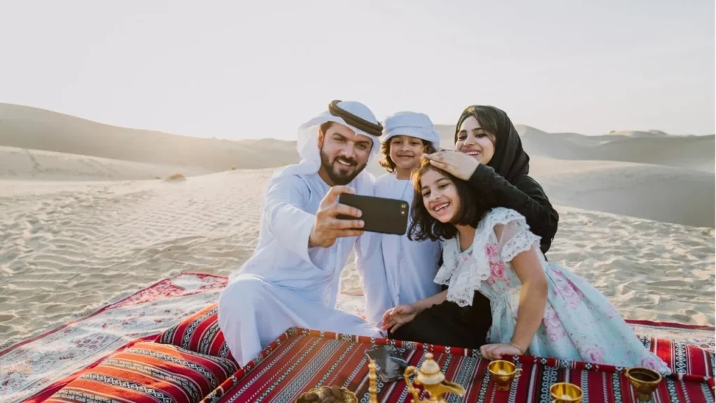 Tourist taking selfie during a luxury desert safari in Abu Dhabi with dinner on sand dunes