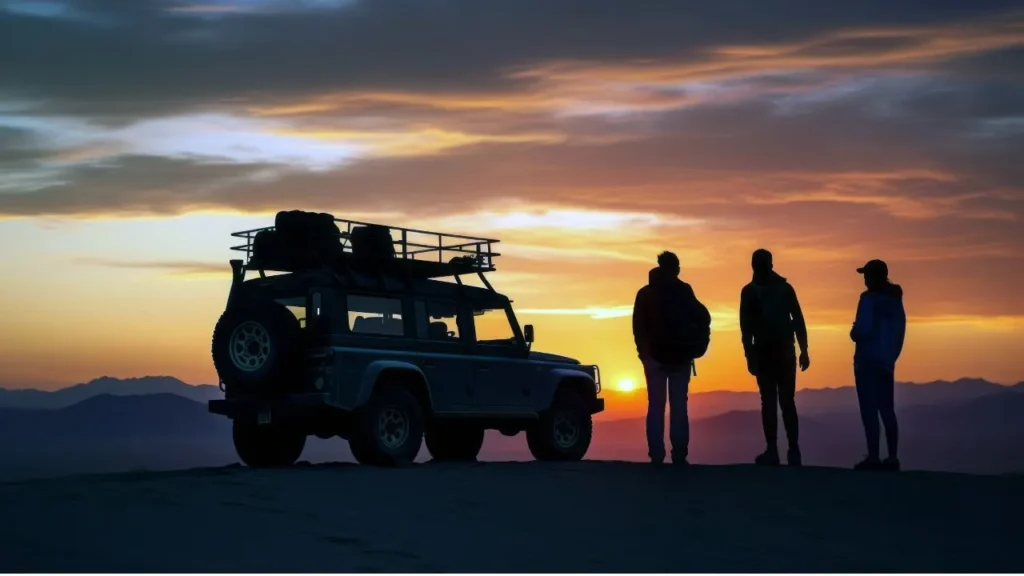 Three men enjoying an overnight desert safari in Abu Dhabi with a 4x4 vehicle, dune bashing under 
